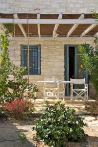 a patio with a table and chairs on a house at Nomads House in Logaras