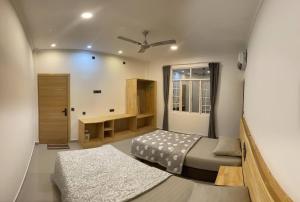 Dhonveli Inn, Bandidhoo في ميدهو: غرفة نوم صغيرة بسريرين ومكتب
