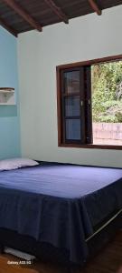 a large bed in a room with a window at Kerala Guest House Vegan in Caraguatatuba
