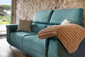 un canapé bleu avec un chat assis sur une serviette dans l'établissement Quinta Alcaparras, à Porto Santo