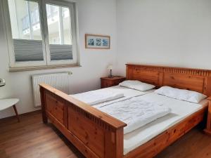 a large wooden bed in a bedroom with a window at Ferienwohnung 9 in der Strandstraße in Müritz