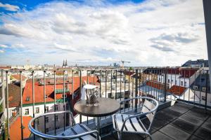 stół i krzesła na balkonie z widokiem w obiekcie Stanys - Das Apartmenthotel w Wiedniu