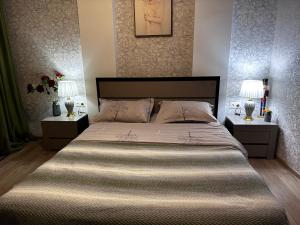 1 dormitorio con 1 cama grande y 2 mesitas de noche en AnnaMari en Tiflis