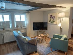 een woonkamer met 2 stoelen en een televisie bij Altstadtliebe Salzuflen in Bad Salzuflen
