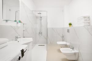 - une salle de bains blanche avec 2 lavabos et 2 toilettes dans l'établissement Blissful Haven Flats, à Oradea 16 autres photos