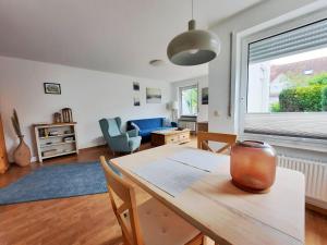 un soggiorno con tavolo in legno e una sala da pranzo. di Haus Heidelbeere 22 a Graal-Müritz