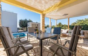 a patio with a table and chairs and a pool at Gorgeous Home In Mandre With Wifi in Mandre