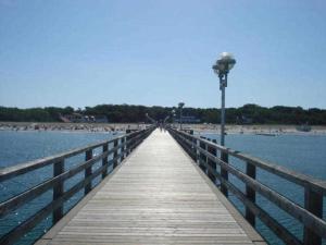 a wooden pier with a light on the beach at Haus Heidelbeere 26 in Graal-Müritz