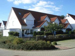 a large white house with a fence in front of it at Haus Heidelbeere 26 in Graal-Müritz