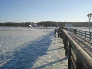 a wooden pier with snow on the water at Haus Heidelbeere 26 in Graal-Müritz +18 photos
