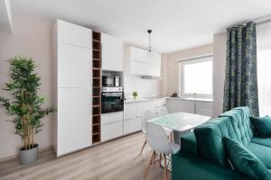 un salon avec un canapé vert et une table dans l'établissement Blissful Haven Flats, à Oradea