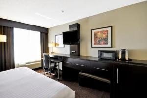 a hotel room with a bed and a desk at Holiday Inn Express Romulus / Detroit Airport by IHG in Romulus