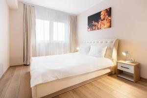 une chambre blanche avec un lit blanc et une fenêtre dans l'établissement Blissful Haven Flats, à Oradea