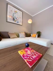 ein Wohnzimmer mit einem weißen Sofa und einem Tisch in der Unterkunft Wohnung mitten in der Altstadt in Koblenz