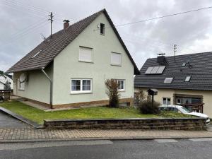 una casa blanca con techo negro en Ferienwohnung Weinbergglück en Lauda-Königshofen