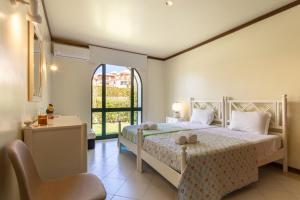 a bedroom with a bed with a chair and a window at TAC - Vila Tina Vilamoura in Quarteira