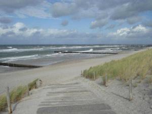 a sandy beach with waves in the ocean at Haus Malta - Strandstraße in Müritz