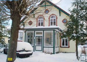 una casa con nieve delante en Haus Paula - Am Rhododendronpark, en Graal