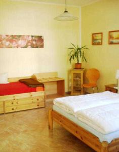 1 dormitorio con 2 camas y escritorio con planta en Haus Paula - Am Rhododendronpark, en Graal