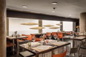 a restaurant with tables and chairs with wine glasses at Hotel Madanis in Barcelona