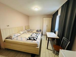 Cette petite chambre comprend deux lits et une table. dans l'établissement Urban Life Tirana- Economy Rooms, à Tirana