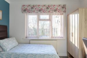 a bedroom with a bed and a window at Apple House Wembley in Barnet