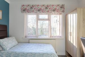 1 dormitorio con cama y ventana en Apple House Wembley, en Barnet