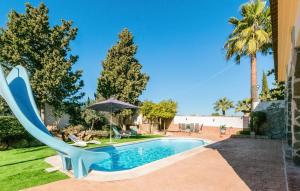 a swimming pool with a chair and an umbrella at 3 Bedroom Awesome Home In Casariche in Casariche