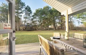 a porch with a table and a view of a yard at 4 Bedroom Lovely Home In Sjællands Odde in Yderby +10 photos