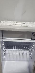 um frigorífico branco com uma prateleira vazia em Large Gated King Bed Apartment in Central Kingston em Kingston