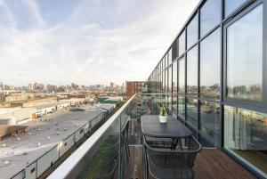a balcony with a table and a view of a city at The Bow Flats in London