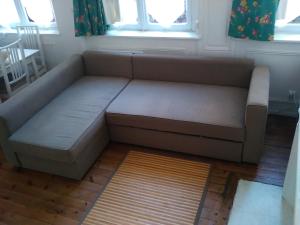 a couch sitting in a living room next to a window at Dieppe Coeur de Ville in Dieppe