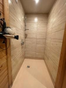 y baño con ducha y paredes de madera. en Classic Latvian Sauna and Hot Tub in a quiet place, en Mālpils