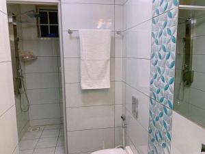 a white bathroom with a shower and a toilet at Spire Plaza 2 bedroom apartment in Nairobi