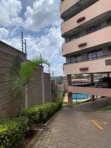 a building with a palm tree next to a street at Spire Plaza 2 bedroom apartment in Nairobi