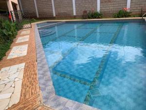 a swimming pool with blue water in a yard at Spire Plaza 2 bedroom apartment in Nairobi