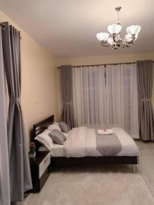 1 dormitorio con cama y lámpara de araña en Spire Plaza 2 bedroom apartment en Nairobi