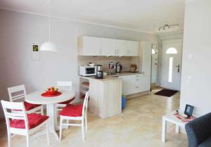 eine Küche und ein Wohnzimmer mit einem Tisch und Stühlen in der Unterkunft Küstenwald - Ferienwohnung Abendsonne in Müritz