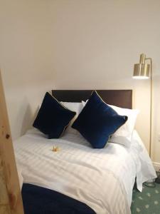 a bed with blue and white pillows on it at Cosy City Apartment in Cork