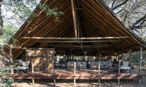 een groot houten paviljoen met stoelen en tafels bij Mashatu Tent Camp in Lentswelemoriti +21 foto's