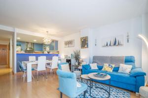 a living room with a blue couch and a dining room at Apartamento ROYAL MARINE in Empuriabrava