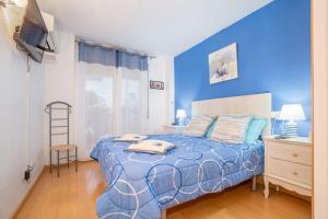 a blue bedroom with a bed and a chair at Apartamento ROYAL MARINE in Empuriabrava
