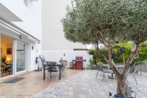 a patio with a table and chairs and a tree at Apartamento ROYAL MARINE in Empuriabrava