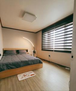 a bedroom with a bed and a window with blinds at Peace and Quiet in Seoul