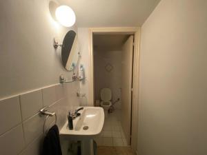 a bathroom with a sink and a toilet and a mirror at Comfortable 2BR Apartment & Office & Fitness Room in Ayios Dhometios