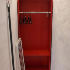 um armário com uma porta vermelha com cabides em Love story em Mala