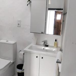 a white bathroom with a sink and a mirror at Love story in Mala