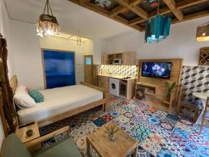 a living room with a bed and a tv at Studio Nature of Sea in the city center in Antalya