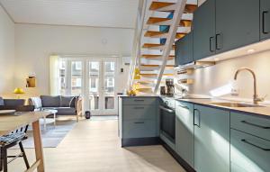 uma cozinha com armários azuis e uma sala de jantar em Nice Apartment In Vestervig With Sauna em Vestervig
