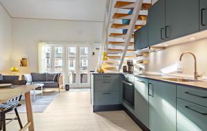 VestervigにあるNice Apartment In Vestervig With Saunaのキッチン(青いキャビネット付)、ダイニングルーム